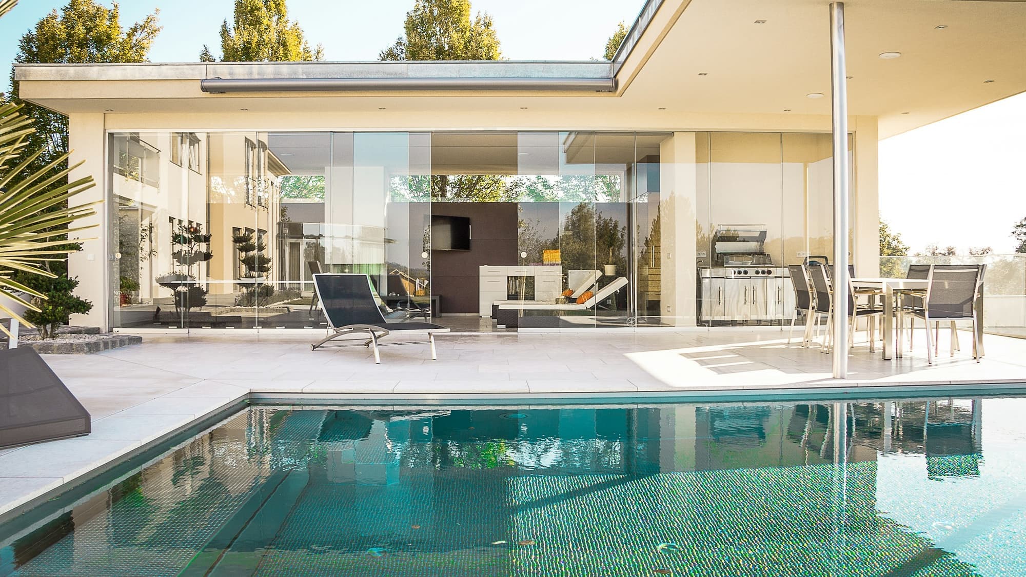 A well-kept Negril villa at golden hour — warm lights on, a host setting the terrace for arrival