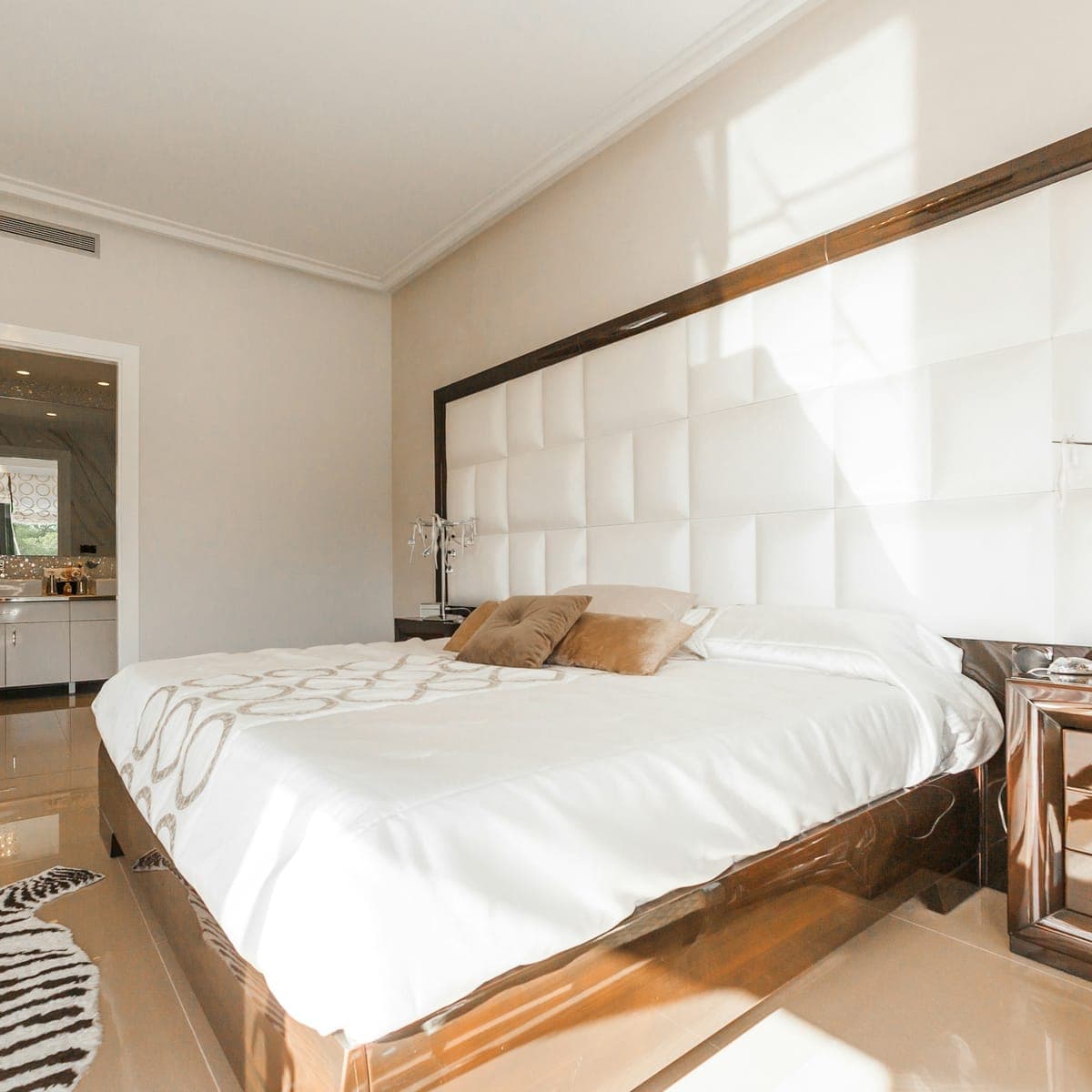 West-facing bedroom — louvers open, low sun striping the bed