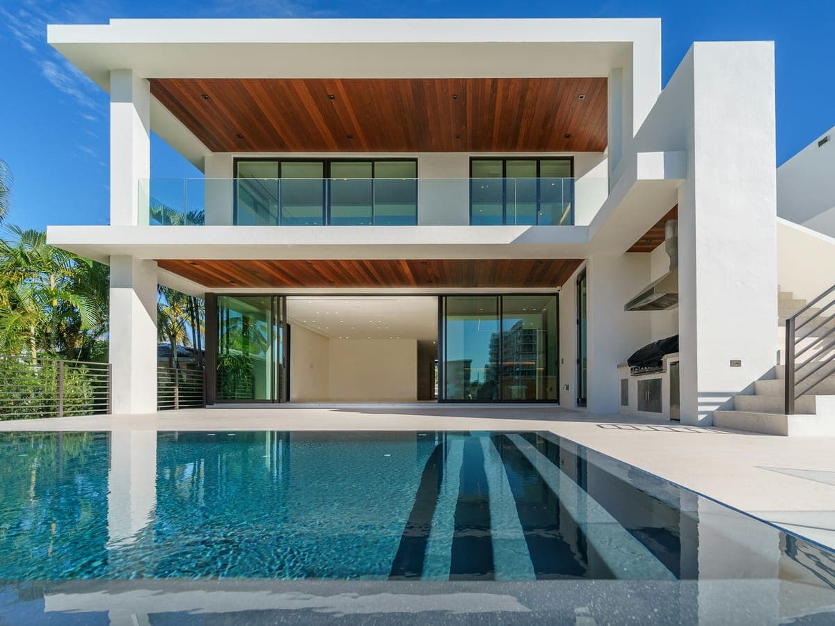 Seagrape House from the sand — white walls, deep shade, calm water