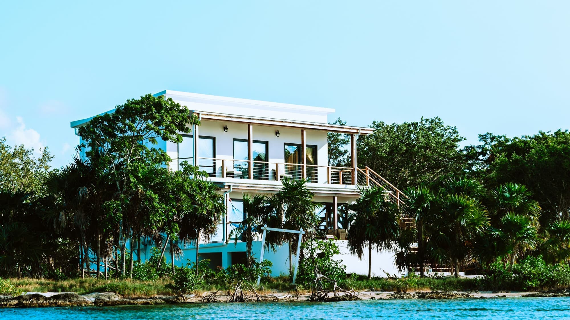 Seagrape House — low white house under seagrape trees, Bloody Bay beyond